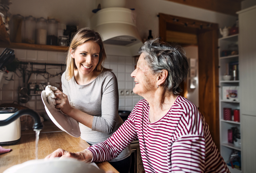 Young woman helping senior with the dishes